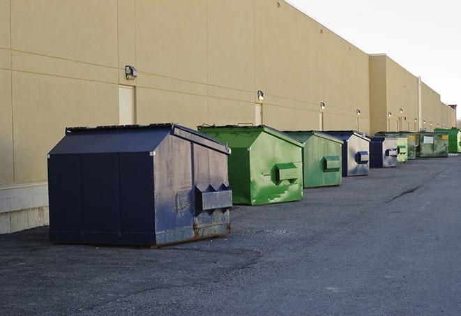 a waste management truck unloading into a construction dumpster in Arnold